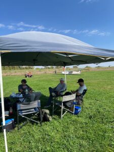 Club Members sit beneath the shade canopy while the L-23 is retrieved after a flight.